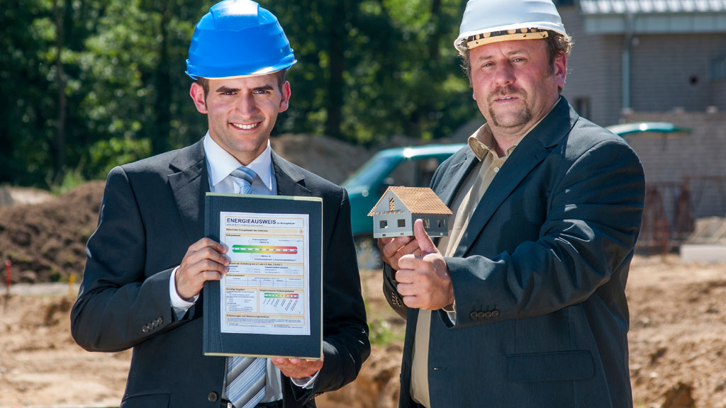 Propriétaire discutant avec un artisan devant une maison avant travaux d'amélioration DPE